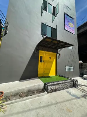 a yellow door on the side of a building at Fit mansion in Sathani Sam Sen