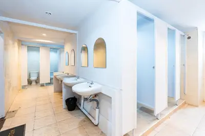 a bathroom with three sinks and two mirrors at XX The Hidden Khaosan - เดอะ ฮิดเด้น ถนนข้าวสาร in Bang Bua Thong Railway Station