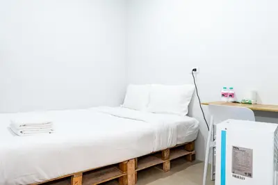 a bed in a room next to a desk at XX The Hidden Khaosan - เดอะ ฮิดเด้น ถนนข้าวสาร in Bang Bua Thong Railway Station