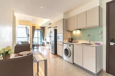 a kitchen with a washer and dryer in a room at Free Airport Pick Up Rooftop Pool Gym near BTS Emquartier Shopping city center in Bangkok