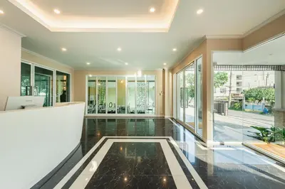 an empty lobby with black tile floors and windows at ZAYN Bangna Hotel in Bangna