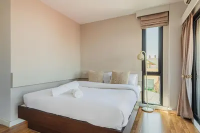 a bedroom with a large white bed and a window at ZAYN Bangna Hotel in Bangna