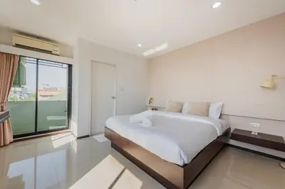 a white bedroom with a large bed and a window at ZAYN Bangna Hotel in Bangna