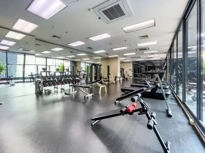 a gym with rows of exercise bikes and treadmills at BTS Thong Lol Large 52 sqm l Pool and Gym l Sontana in Bangkok