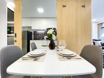 a white dining room table with chairs and glasses at BTS Thong Lol Large 52 sqm l Pool and Gym l Sontana in Bangkok