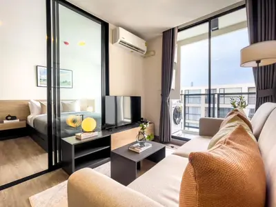 a living room with a couch and a large window at Near BTS - Near Iconsiam - Pool and Gym - Sontana in Bangkok