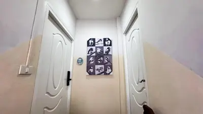 a hallway with two white doors and pictures on the wall at Blissful Heaven Residence at BTS Phromphong Emdistrict Shopping Area in Bangkok