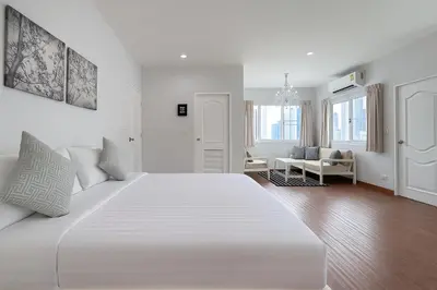 a white bedroom with a large white bed in a room at Blissful Heaven Residence at BTS Phromphong Emdistrict Shopping Area in Bangkok