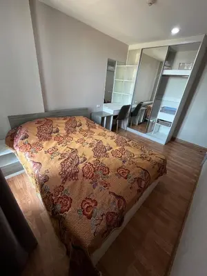 a bedroom with a bed with a flowered blanket at AC Home 1 Laksi in Lak Si