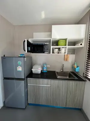 a small kitchen with a refrigerator and a microwave at AC Home 1 Laksi in Lak Si
