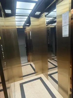 a hallway with elevator doors in a building at TUAN Hotel Bangkok in Bangkok Yai