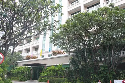 a large white building with trees in front of it at 14 Place in Bangkok