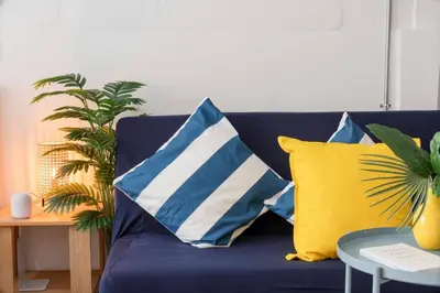 a blue couch with pillows and a table at Soulful Stay-Hidden Thai-Mediterranean Retreat. in Bangkok