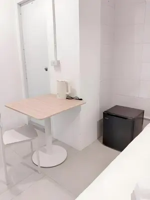 a white room with a table and a trash can at XX Mitr Inn Sukhumvit 2 - มิตร อินน์ สุขุมวิท 2 in Bang Kapi