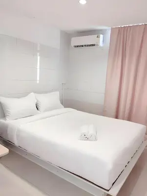 a large white bed with white sheets and pillows at XX Mitr Inn Sukhumvit 2 - มิตร อินน์ สุขุมวิท 2 in Bang Kapi