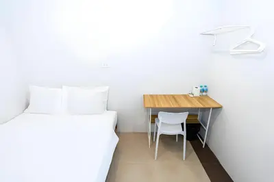 a bedroom with a desk and a bed and a table at XX Mitr Inn Sukhumvit 2 - มิตร อินน์ สุขุมวิท 2 in Bang Kapi