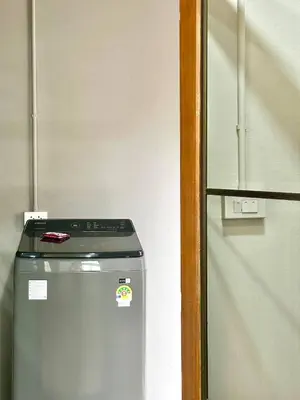 a refrigerator in a kitchen next to a door at Spacious 2BR2BA in Thonglor with WiFi & balcony in Khlong Toei