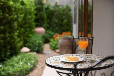 a table with a glass of orange juice and a plate of food at Spacious 2BR2BA in Thonglor with WiFi & balcony in Khlong Toei
