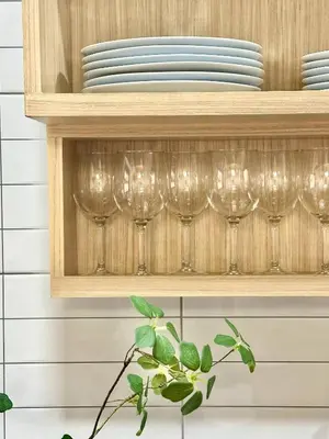 a shelf with wine glasses and plates on it at Spacious 2BD 2BA Apartment in Thong Lor in Khlong Toei
