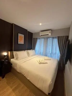 a bedroom with a large white bed with a window at J5 Hotel in Ban Zong Katiam