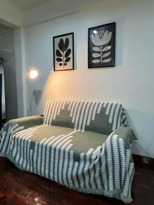 a couch in a room with two pictures on the wall at Baan29 in Bangkok