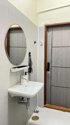 a bathroom with a sink and a mirror and a door at Baan29 in Bangkok
