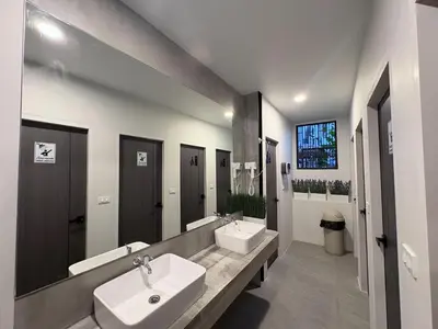 a bathroom with two sinks and two mirrors at City Pause Hostel in Sathani Bang Su