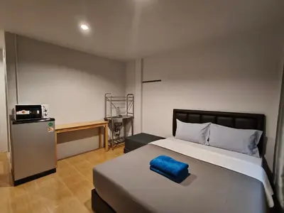 a bedroom with a bed with a blue pillow on it at D45 Home - BTS Ratchathewi N1 Station in Bangkok