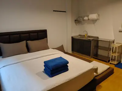 a bedroom with a bed with a blue towel on it at D45 Home - BTS Ratchathewi N1 Station in Bangkok