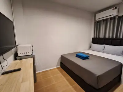 a bedroom with a bed and a flat screen tv at D45 Home - BTS Ratchathewi N1 Station in Bangkok