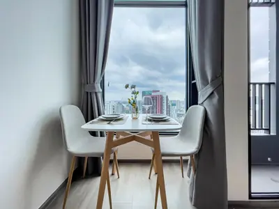 a table and chairs in a room with a window at 250m BTS l Duplex Unit l Rooftop Pool l Sontana in Bangkok