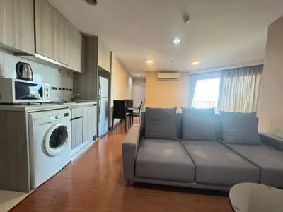a living room with a couch and a washing machine at Sky Apartment - Pool - BTS - Gym - Sauna in Bangkok