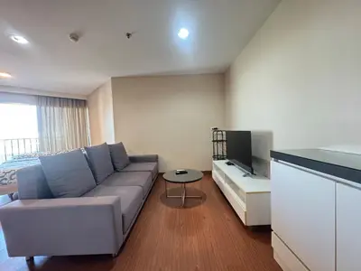 a living room with a couch and a tv at Sky Apartment - Pool - BTS - Gym - Sauna in Bangkok
