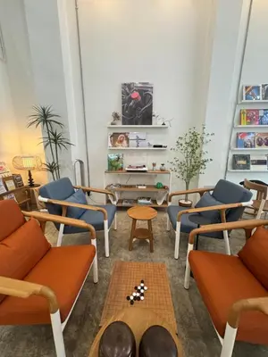 a living room with orange and blue chairs and a table at BubbleHumbleBangkok in Bangkok