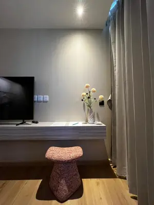 a room with a bench and a television and a stool at BubbleHumbleBangkok in Bangkok