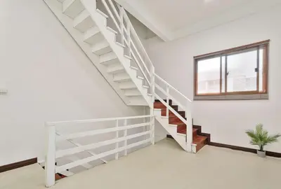 a white staircase in a white room with a window at Siam Central 2BR Yumi house Near IconSiam in Bangkok