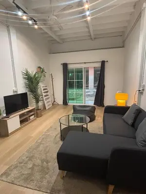 a living room with a couch and a tv at Siam Central 2BR Yumi house Near IconSiam in Bangkok