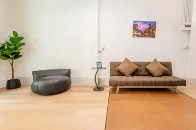 a living room with a couch and a chair at Siam Central 2BR Yumi house Near IconSiam in Bangkok