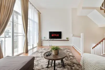 a living room with a bed and a tv at Modern 3BR Rama Mansion Near Airport plus Amenities in Sathani Ban Hua Mak
