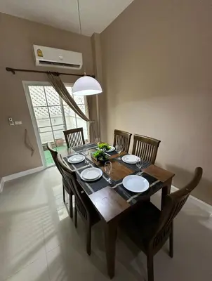 a dining room table with chairs and a wooden table at Modern 3BR Rama Mansion Near Airport plus Amenities in Sathani Ban Hua Mak