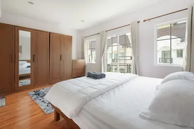 a large white bedroom with a large bed and windows at Modern 3BR Rama Mansion Near Airport plus Amenities in Sathani Ban Hua Mak