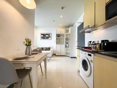 a kitchen with a table and a washing machine at 150m to BTS l Workspace l Pool and Gym l Sontana in Bangkok