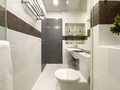 a white bathroom with a toilet and a shower at 150m to BTS l Workspace l Pool and Gym l Sontana in Bangkok