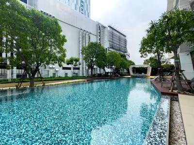 a large swimming pool in the middle of a building at 150m to BTS l Workspace l Pool and Gym l Sontana in Bangkok
