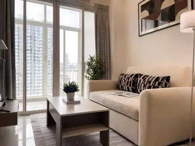 a living room with a couch and a table at 150m to BTS l Workspace l Pool and Gym l Sontana in Bangkok