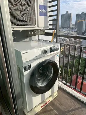 a washing machine with a tv on top of it on a balcony at Free Wi-Fi Private Room I Near the Mall Bangkapi in Bangkok