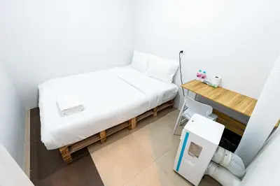 a small bedroom with a bed and a desk at The Hidden Khaosan Bangkok in Bang Bua Thong Railway Station