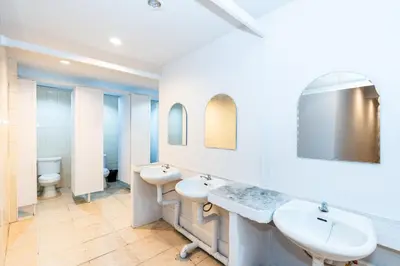 a bathroom with two sinks and two mirrors at The Hidden Khaosan Bangkok in Bang Bua Thong Railway Station
