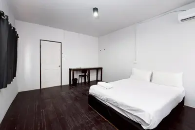 a white bedroom with a bed and a table at XX Mitr Khaosan Bangkok in Bangkok