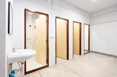 a bathroom with three mirrors and a sink at XX Mitr Khaosan Bangkok in Bangkok